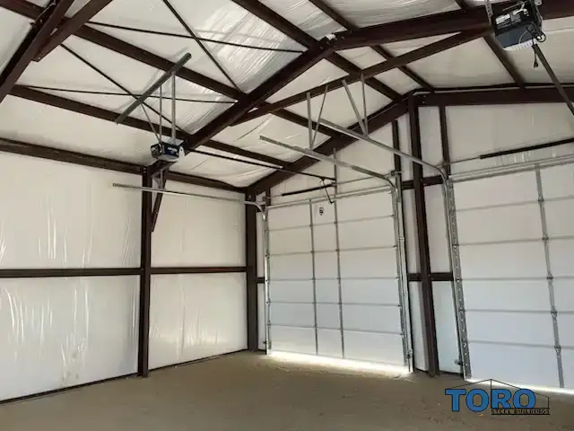Interior of insulated steel garage with roll-up doors.